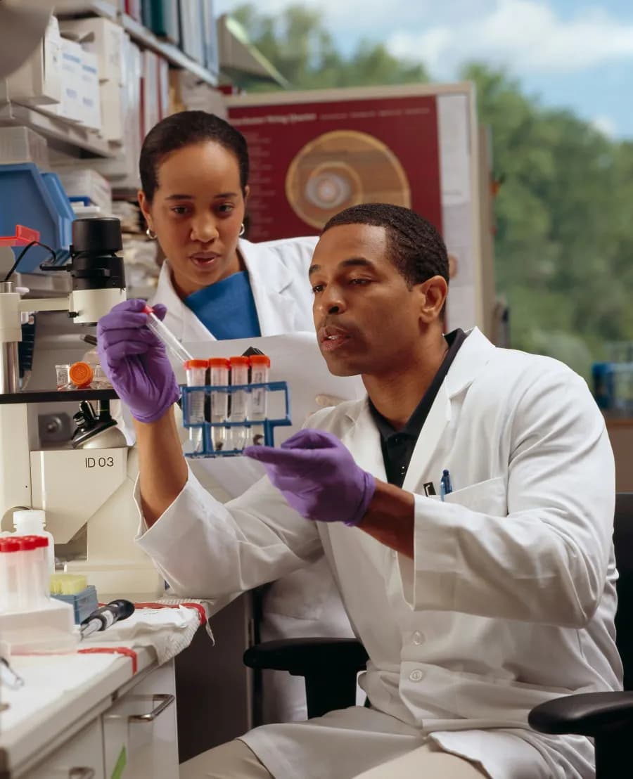 Two researchers in a lab with sample tubes